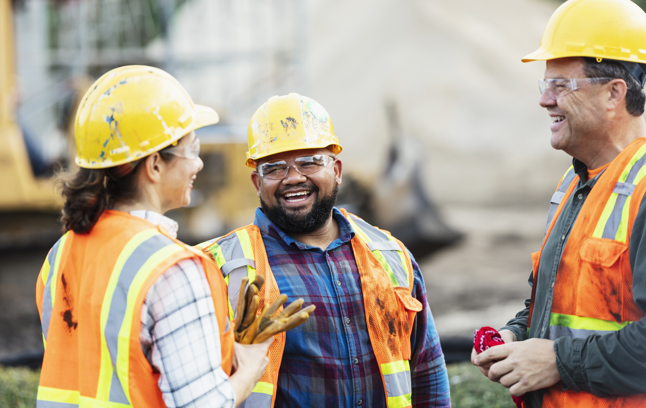 Tres trabajadores de la construcción multiétnicos conversando